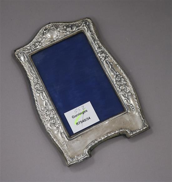 An Art Nouveau silver mounted photograph frame, with a floral embossed border, Birmingham, 1909, 20.3cm.